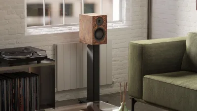 The Kanto TUK G2 in the burl finish, photographed by Kanto next to a turntable it can no longer connect to directly
